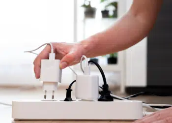 personne qui débranche une des chargeurs sur une multiprise