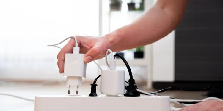 personne qui débranche une des chargeurs sur une multiprise